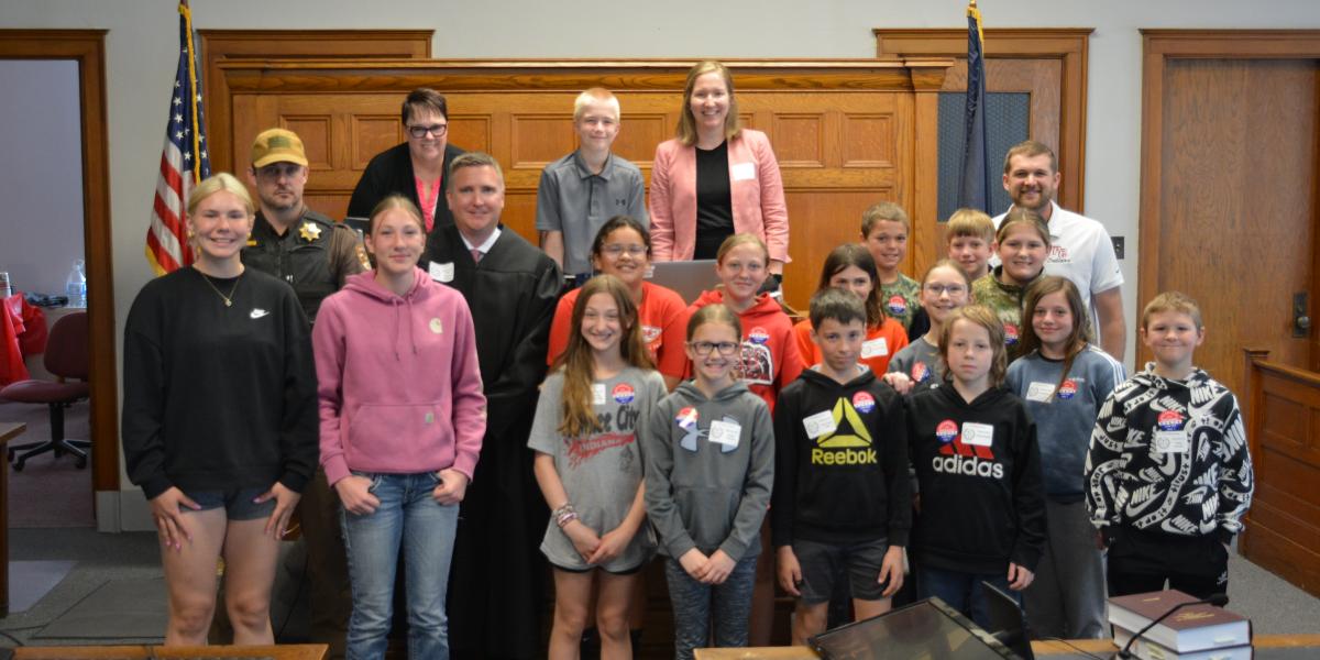 Photo: Judge Richard Smith invites Pawnee City students to the front of the courtroom for a commemorative Law Day photo.