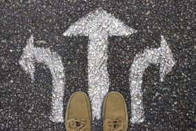 shoes on concrete with painted arrow signs pointing left, forward, and right