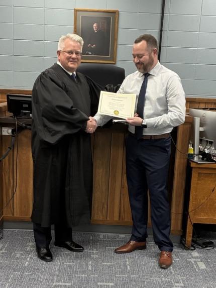 Judge Stephen Twiss presents Certificate of Appointment to Clerk Magistrate Aaron Benson.