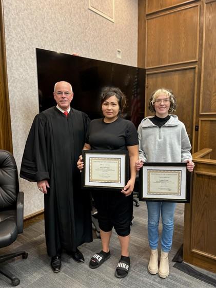 Judge James Kube and graduates Logan and Raquel.