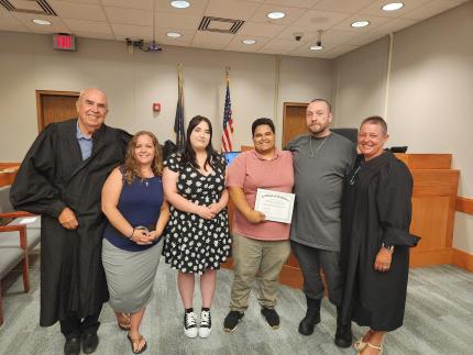 Photo: (L to R) Retired Judge Robert Wester, graduates Jackie, Ana, Devin, and Tim, and Judge Stefanie Martinez.