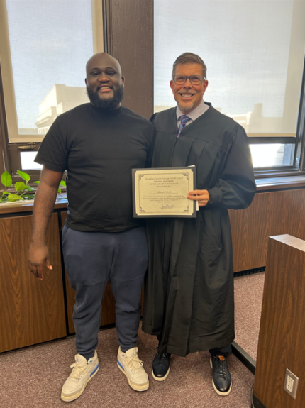 photo: Judge James Masteller with graduate Idumati.